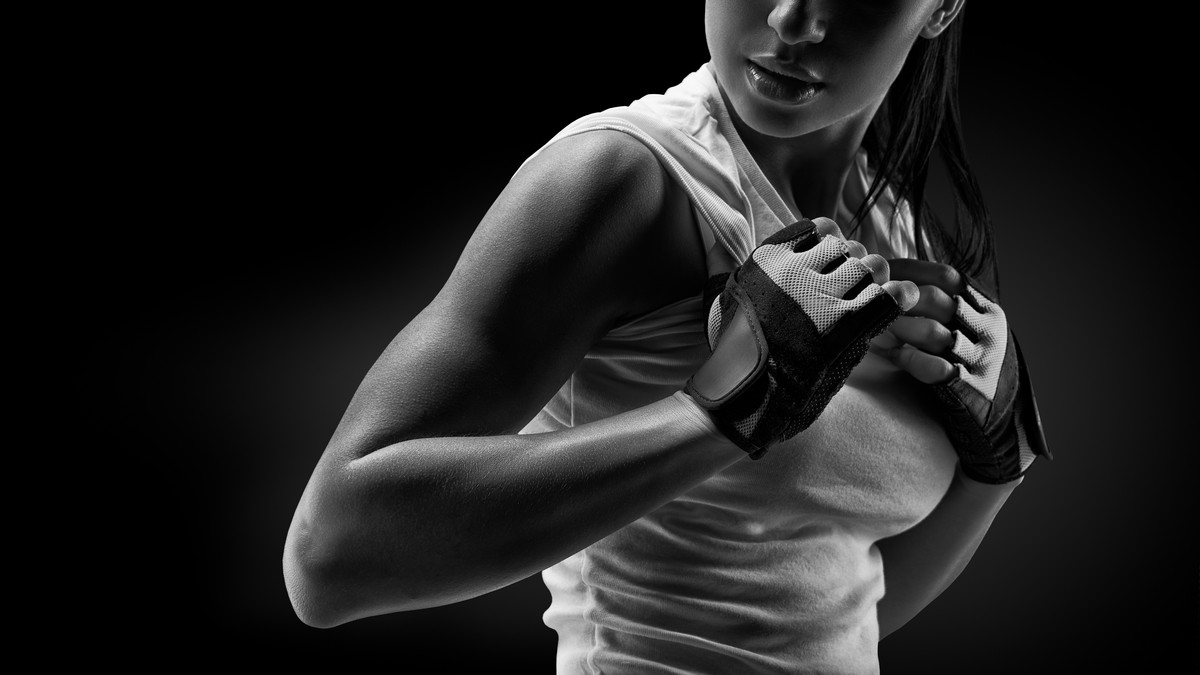 athletic woman with gloves on in grayscale