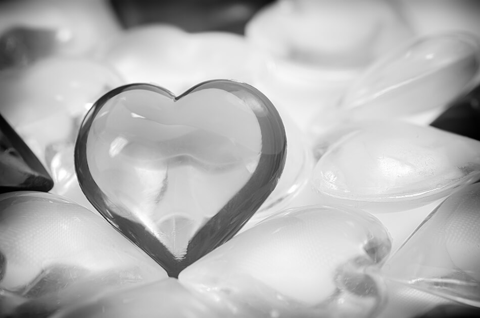 black and white photo of one small glass heart standing out among many