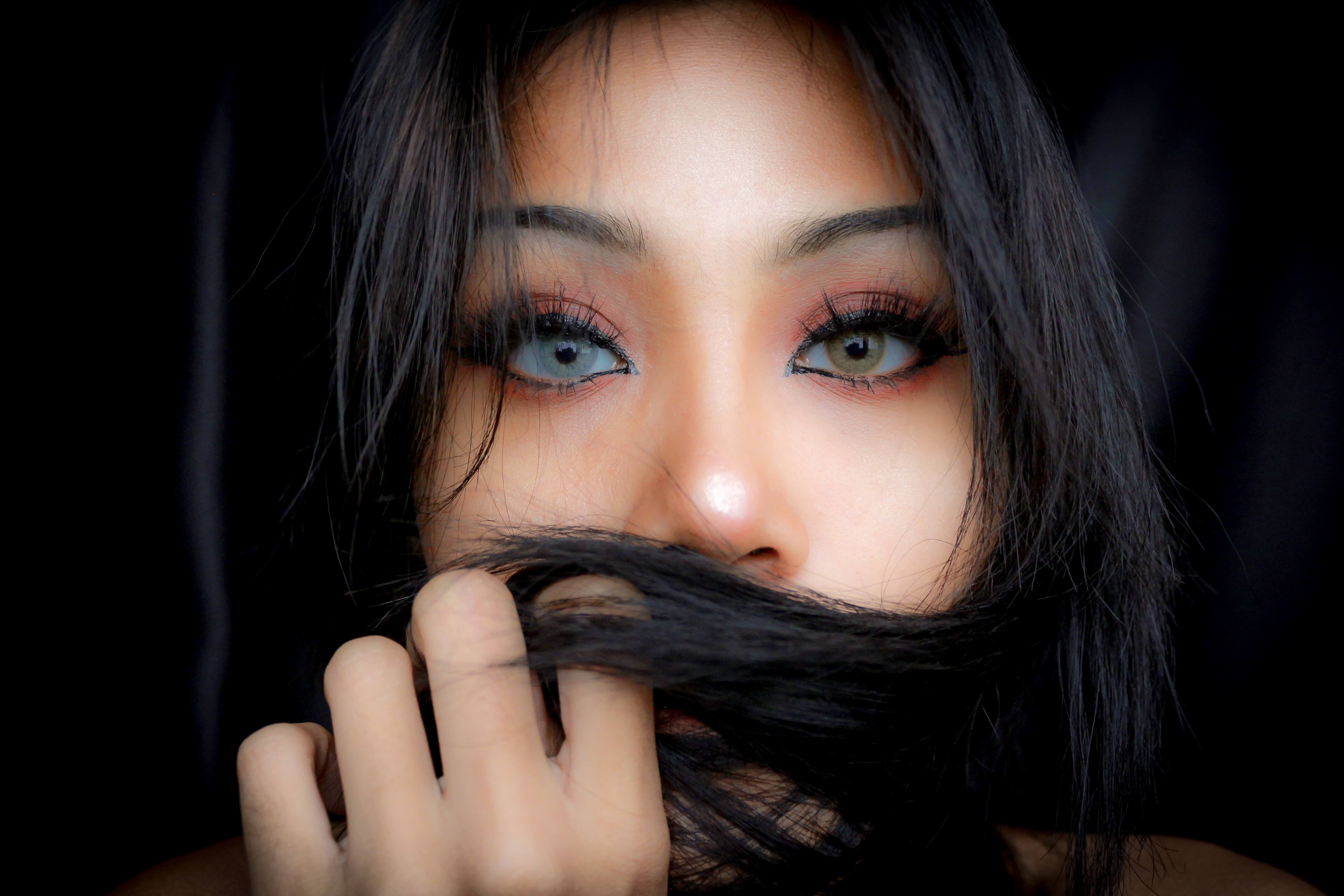 black haired Asian woman with color contact lenses