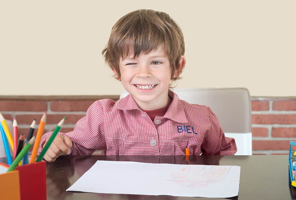 boy closing one eye while doing homework