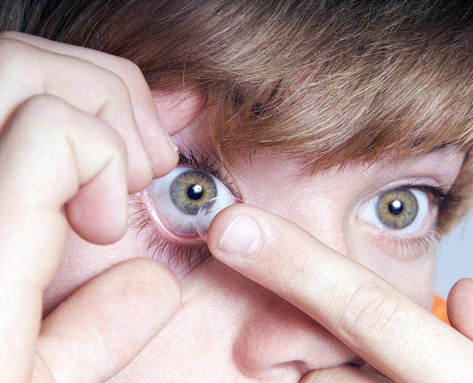 boy putting on contacts for kids in right eye