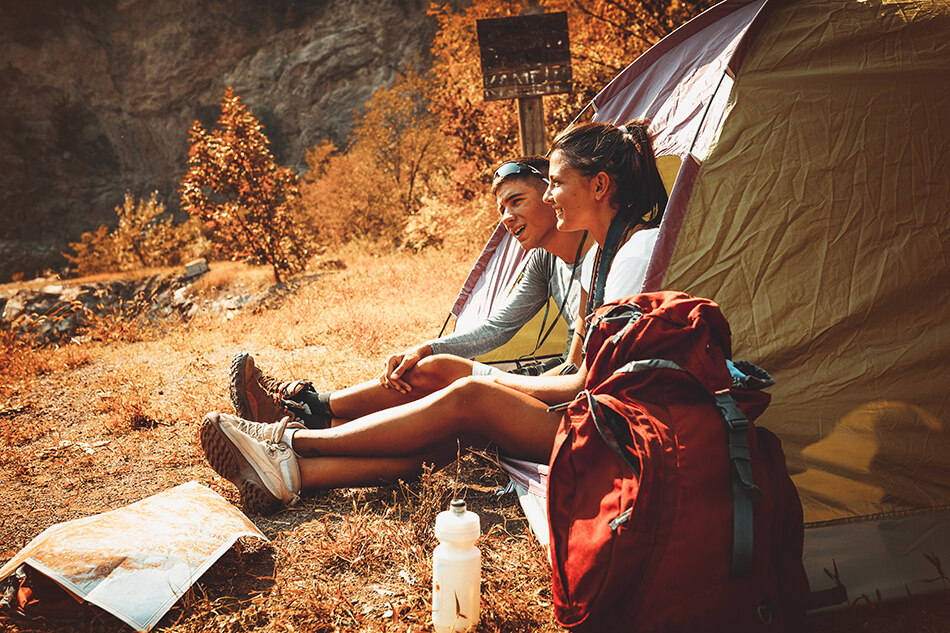young couple sitting in a tent and relaxing