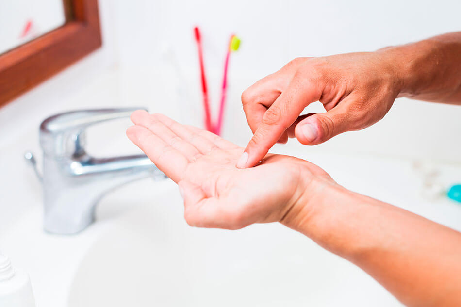 Man cleaning contact lens by rubbing it in his palm