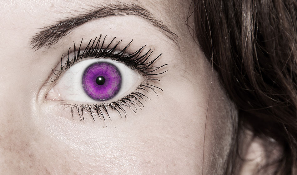 Close-up of woman’s eye with purple colored contact lens