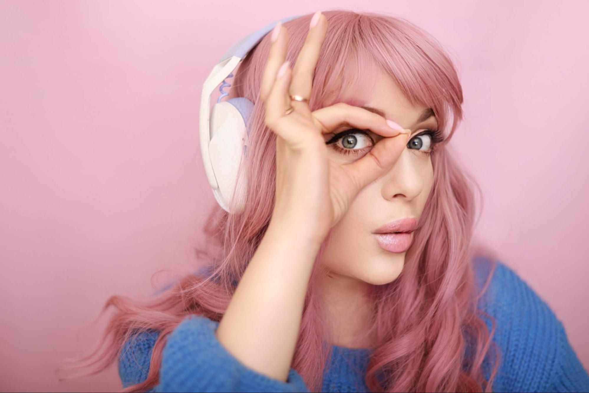 Cosplayer with colored contact lenses and pink wig creating an anime-inspired character look
