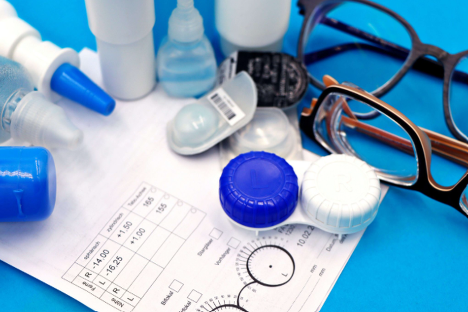 Contact lens accessories, eyeglasses, and eye care supplies on a blue background