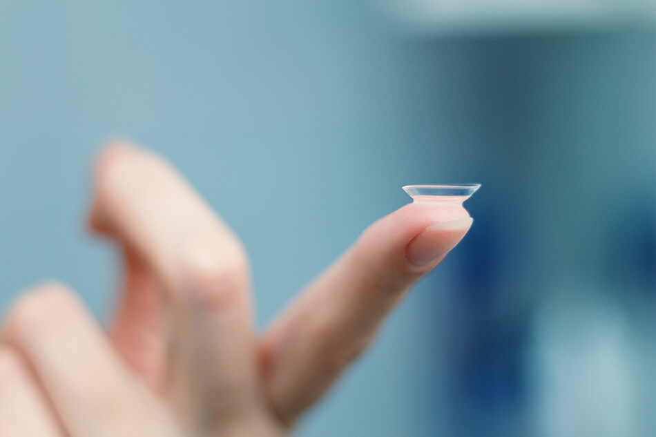contact lens balancing on woman’s finger