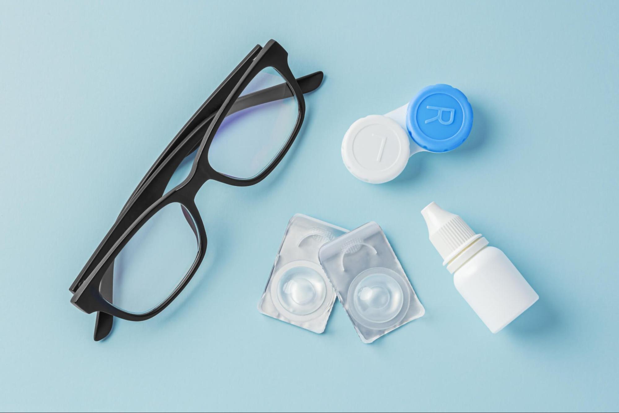 Contact lens care essentials including lenses, case, and eye drops