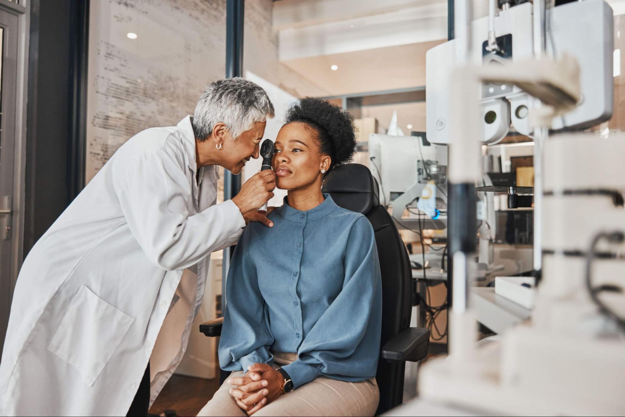 Eye doctor performing a contact lens fitting exam on a patient