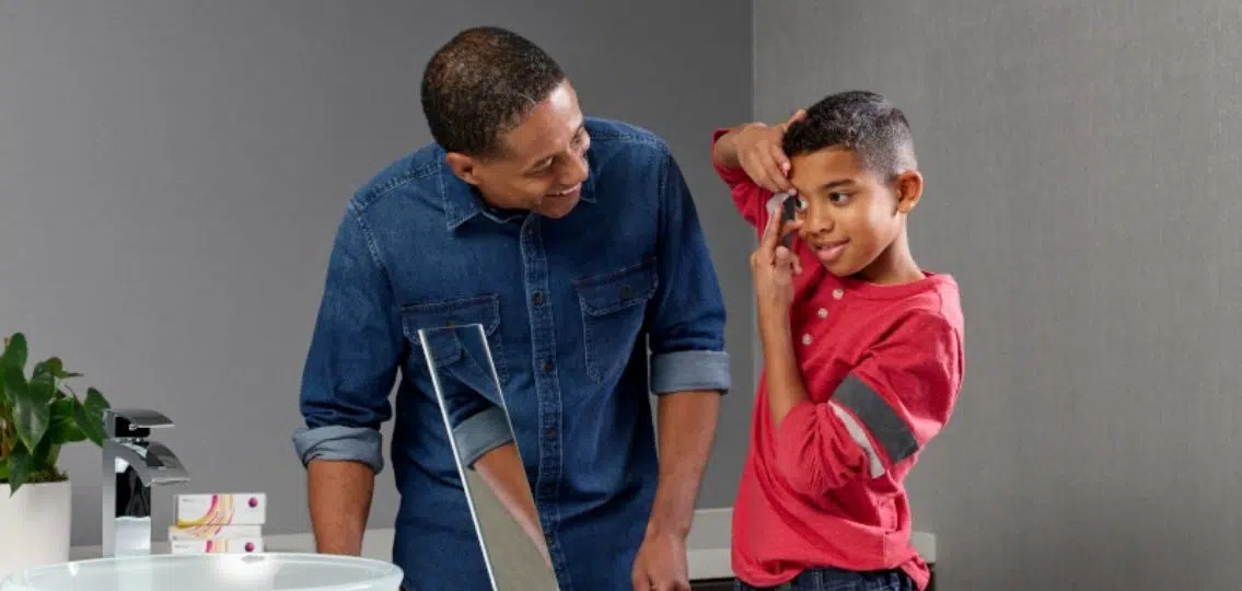 Dad helping young son put in contact lenses for the first time