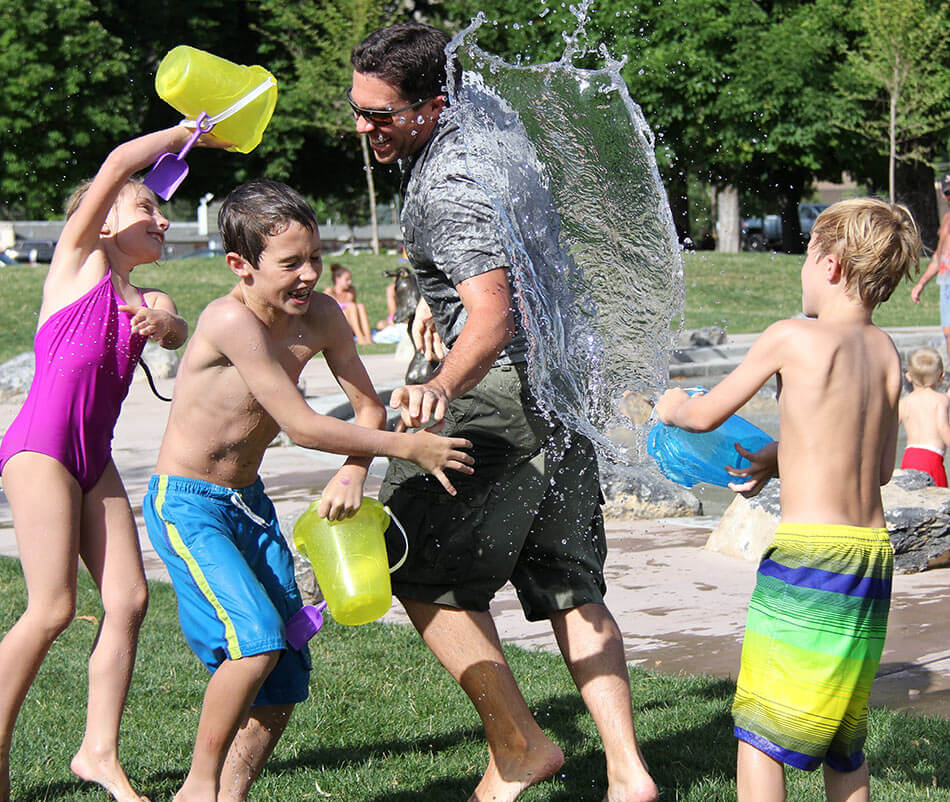 dad and kids enjoy a fun water fight