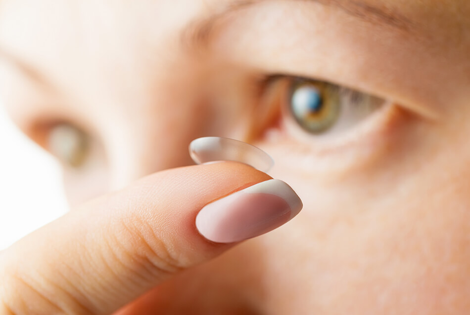 woman putting in daily contact lenses