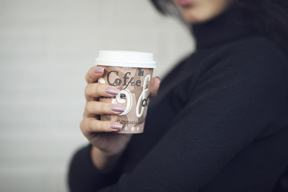 woman with coffee in disposable cup