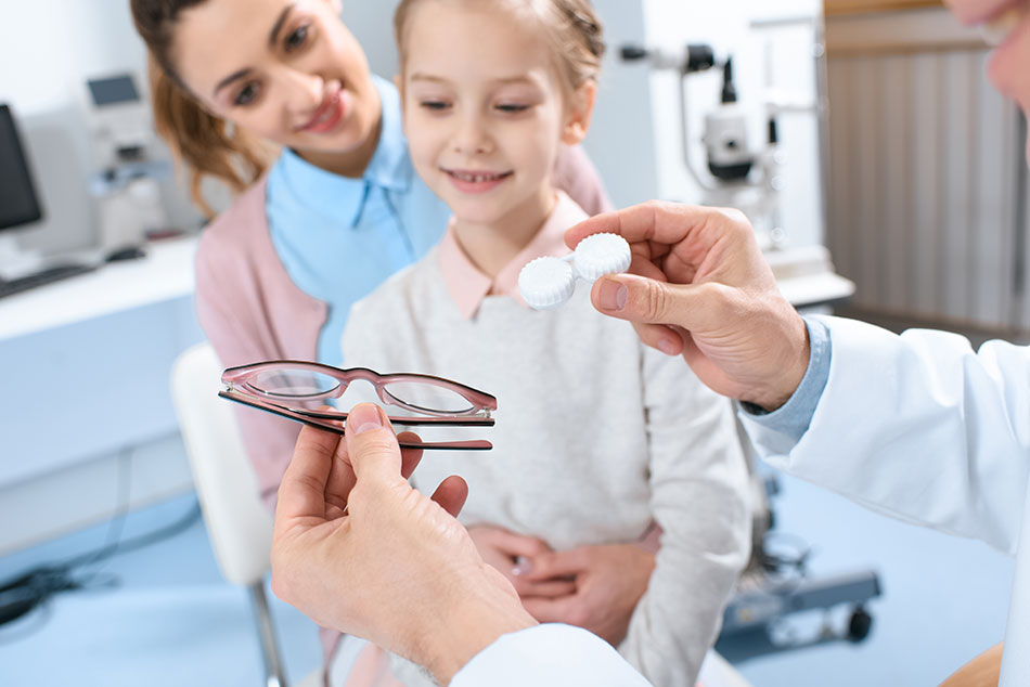eye doctor showing mom and child glasses and contacts for kids