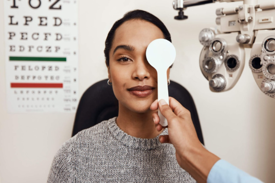 Woman undergoing an eye exam with an optometrist using an eye cover tool