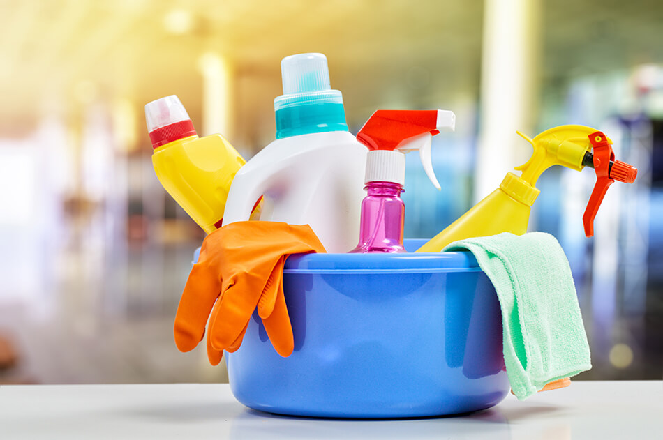 cleaning liquids and gloves in a container