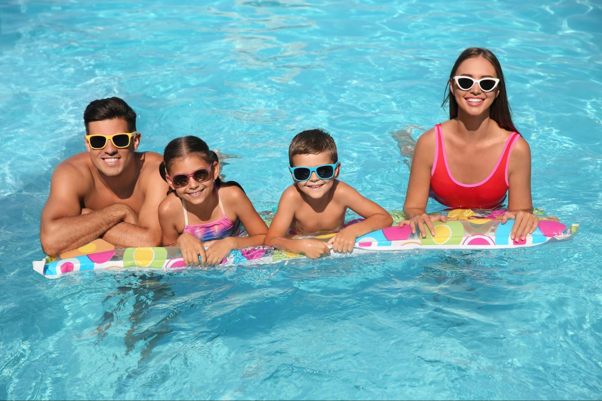 Family wearing adult and kids sunglasses in a swimming pool