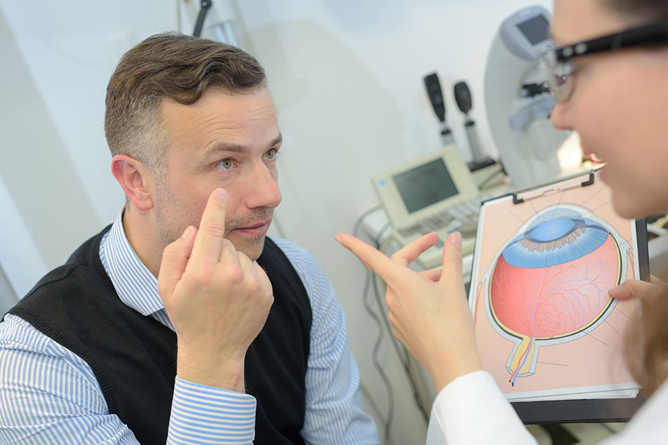 Female eye doctor discussing the shape of the eye with a male patient