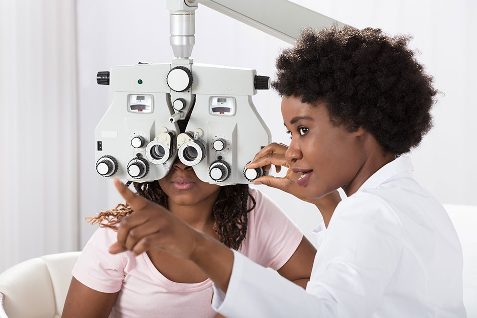 female eye doctor performing eye test on young woman