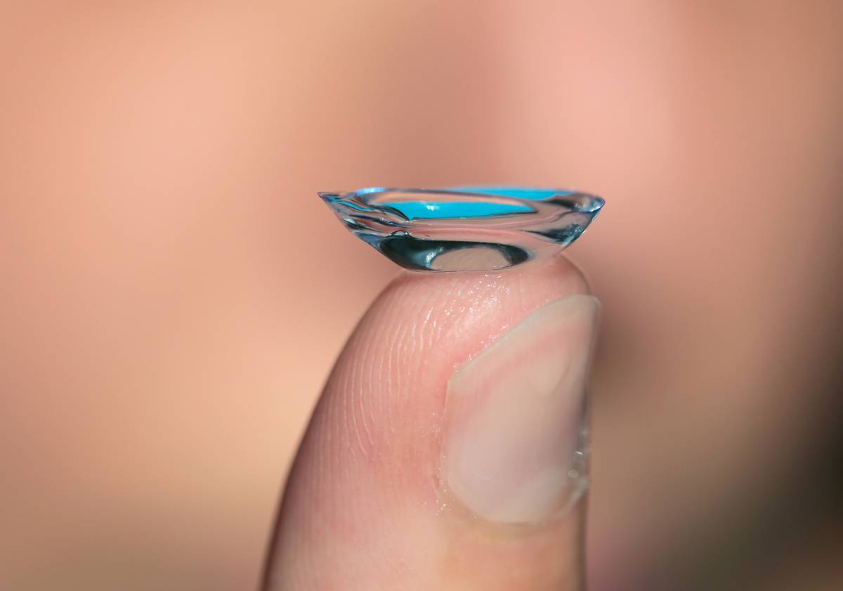 finger holding up bent contact lens