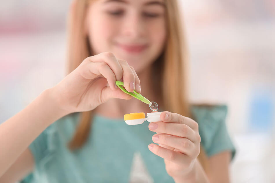 girl taking contact out of case with tweezers