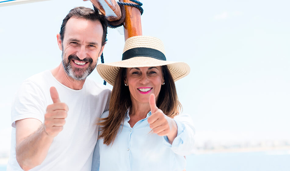 happy middle age couple giving thumbs up sign