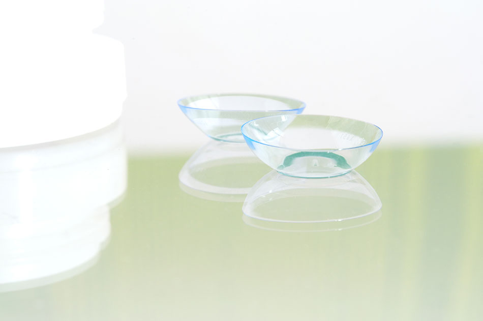 Hard contact lenses beside container