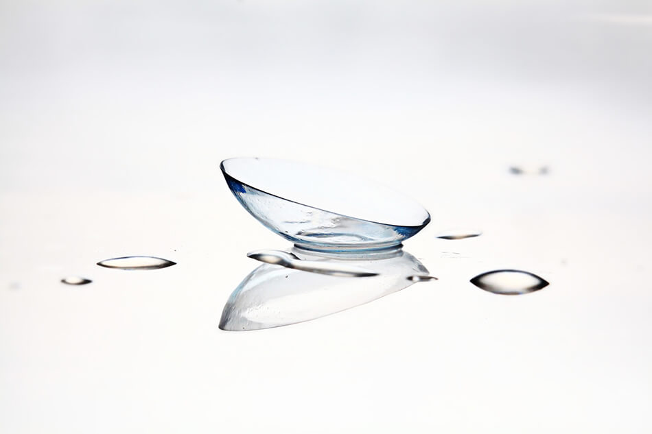 closeup of contact lens on a surface with water droplets