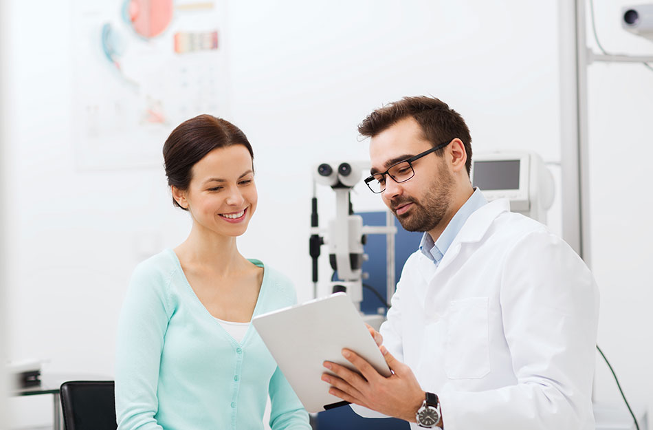 male eye doctor with tablet and female patient