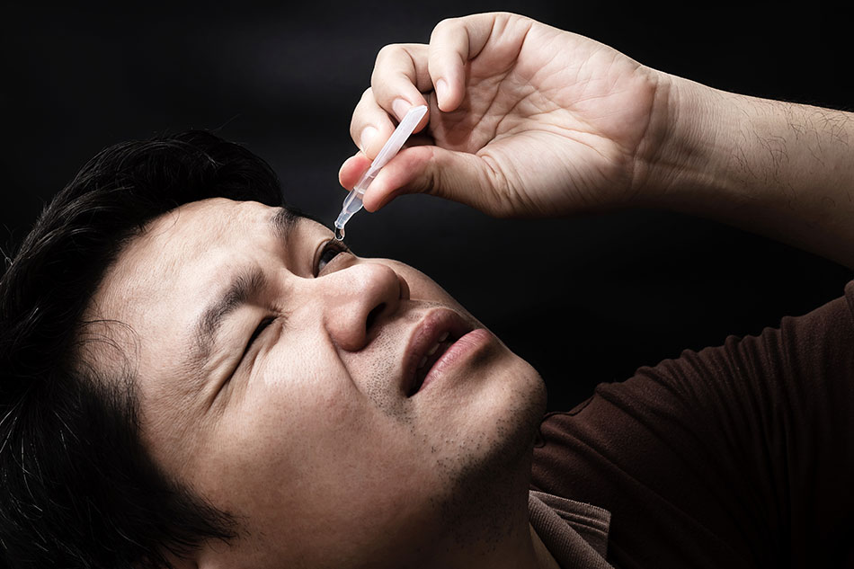 Man putting in some quick relief eye drops
