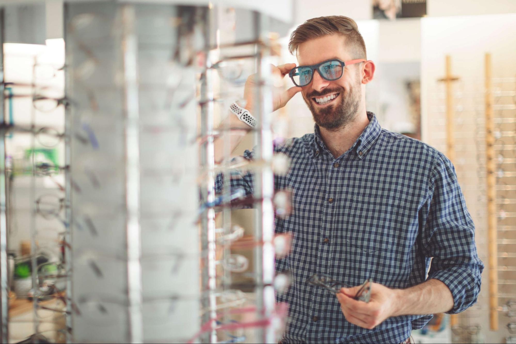 A man trying on UV protection sunglasses in eyewear store