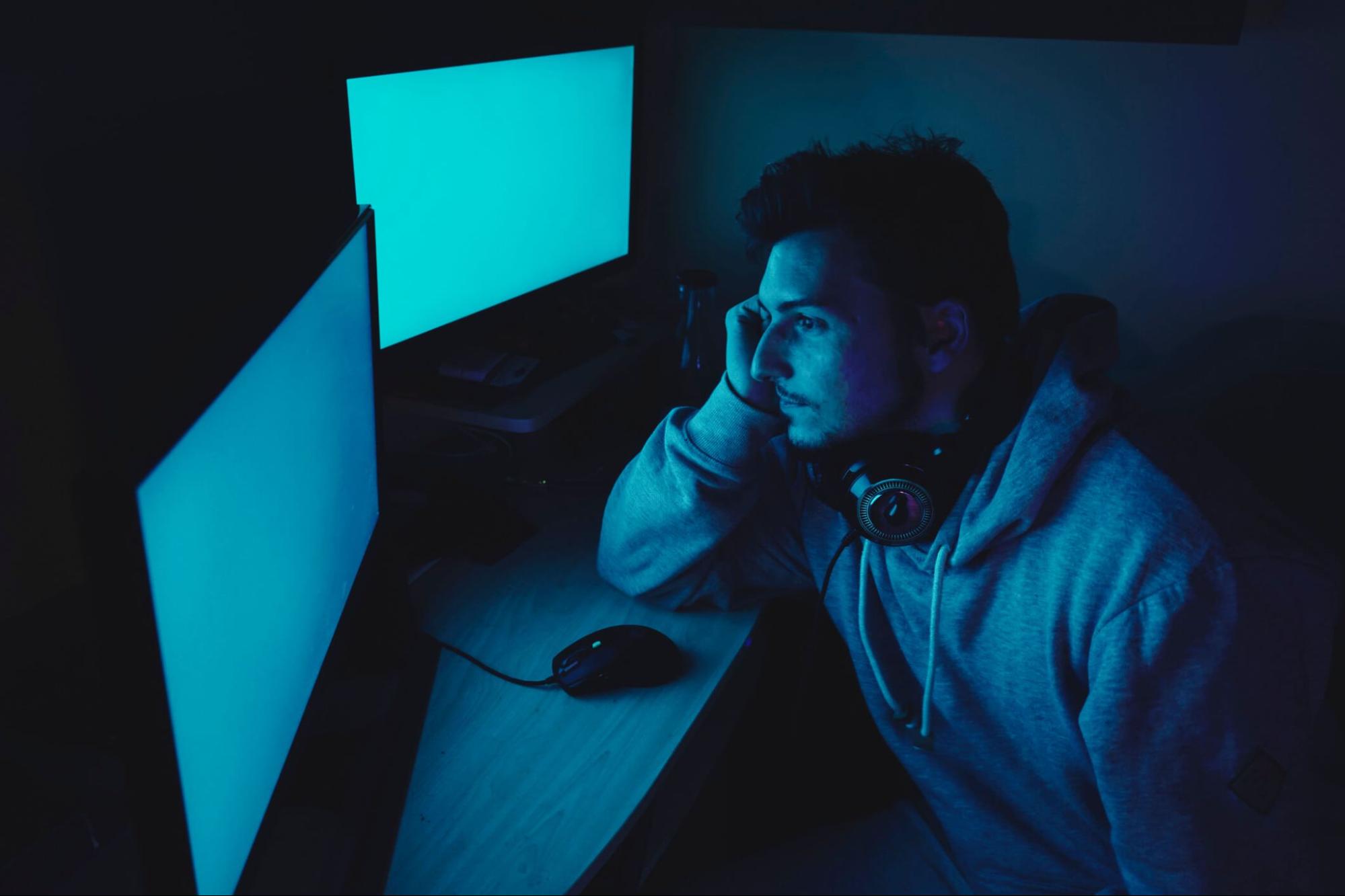 man using computer at night with blue screen light