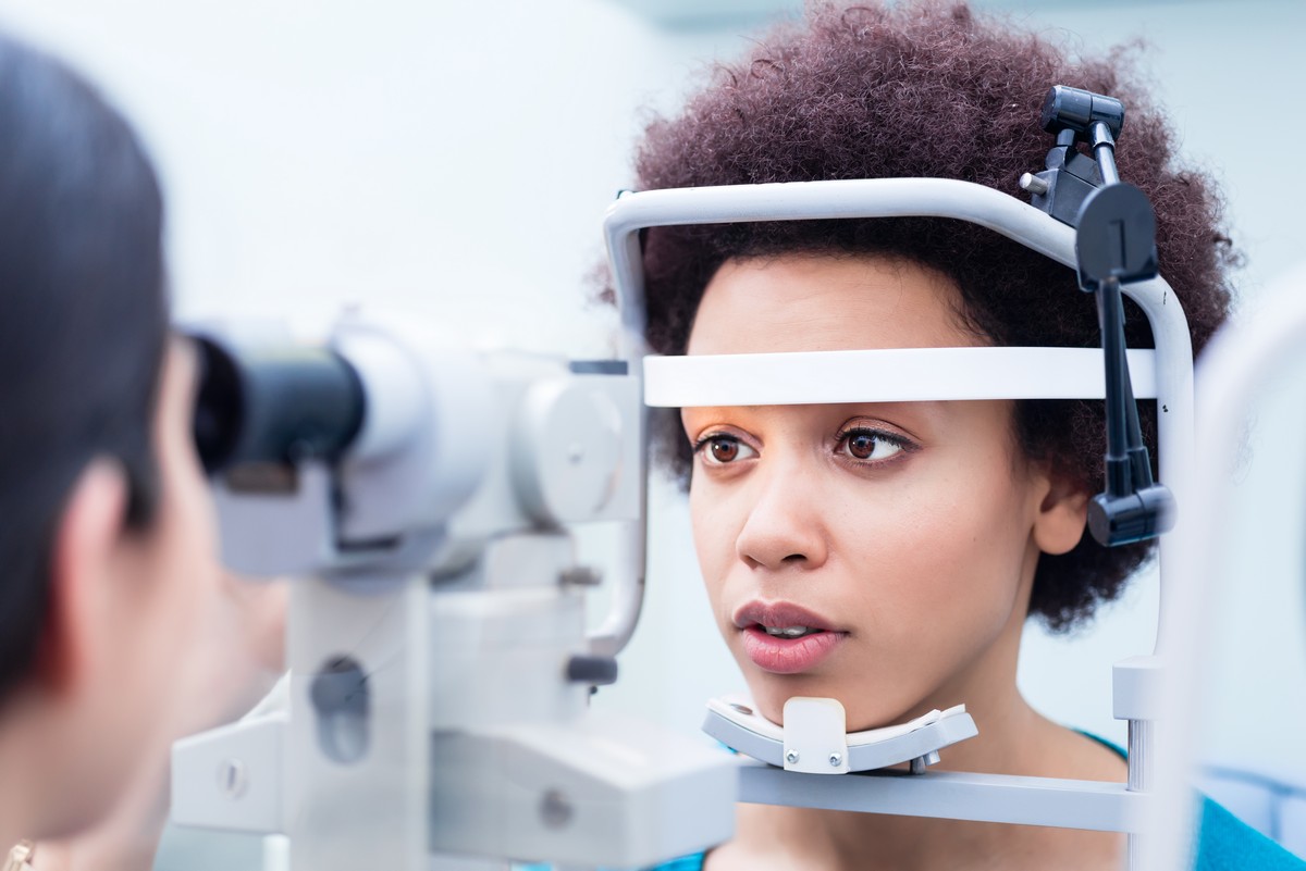 Optometrist measuring young woman’s eyes