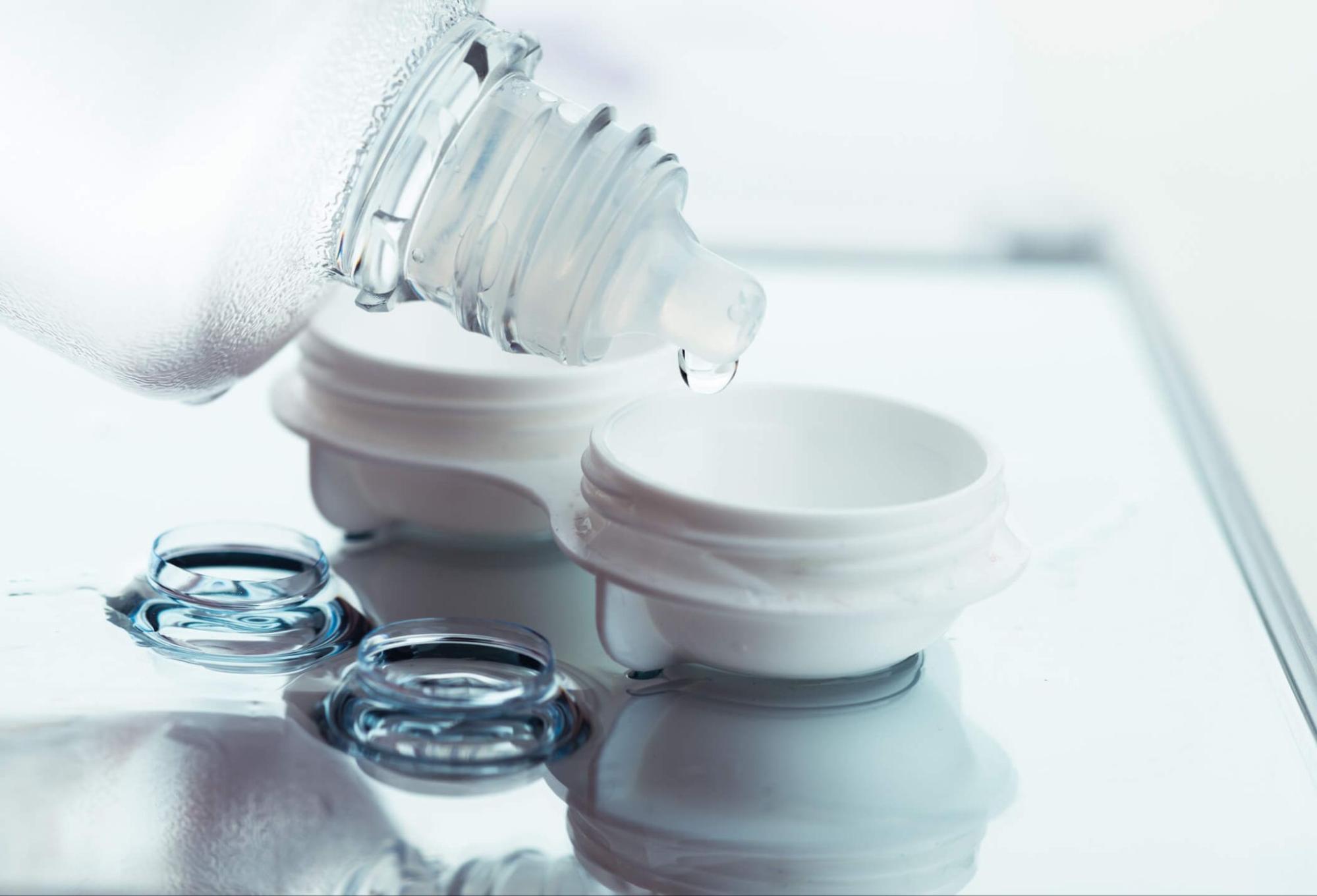 Pouring fresh contact lens solution into a clean case for proper overnight lens storage
