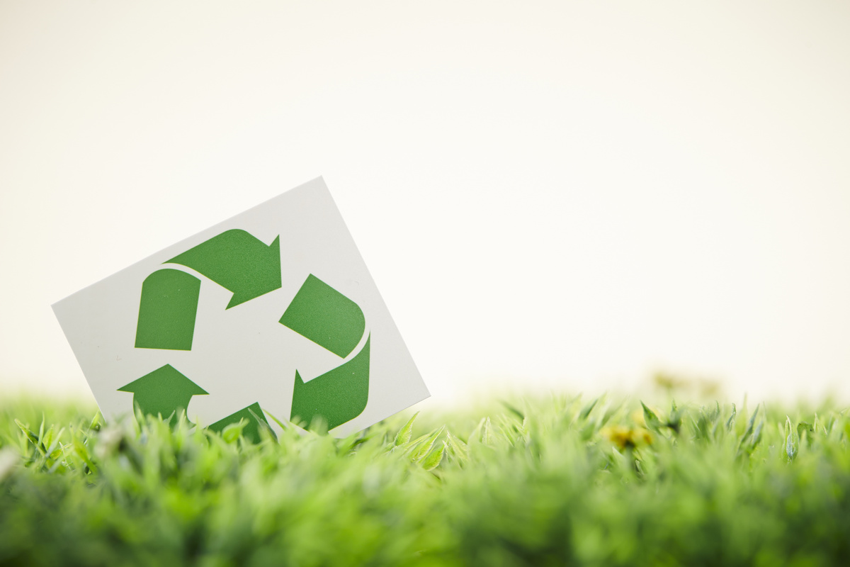 recycling arrows sign in the grass