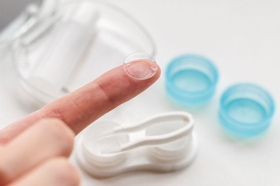 caring for soft contact lens on woman’s finger