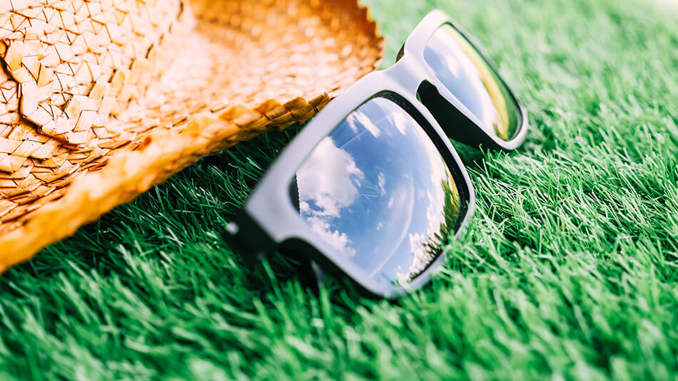 sunglasses and a hat on lawn