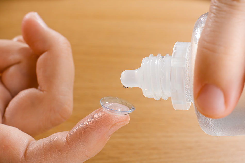 Washing contact lens on fingertip with solution bottle