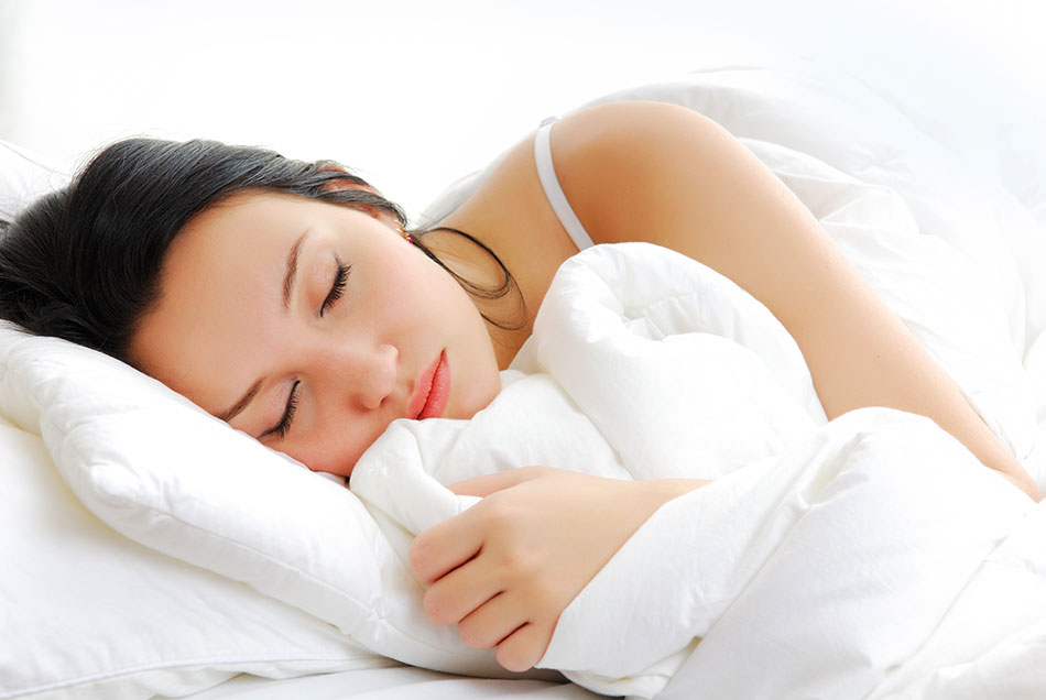 woman asleep in bed with white pillow and blanket