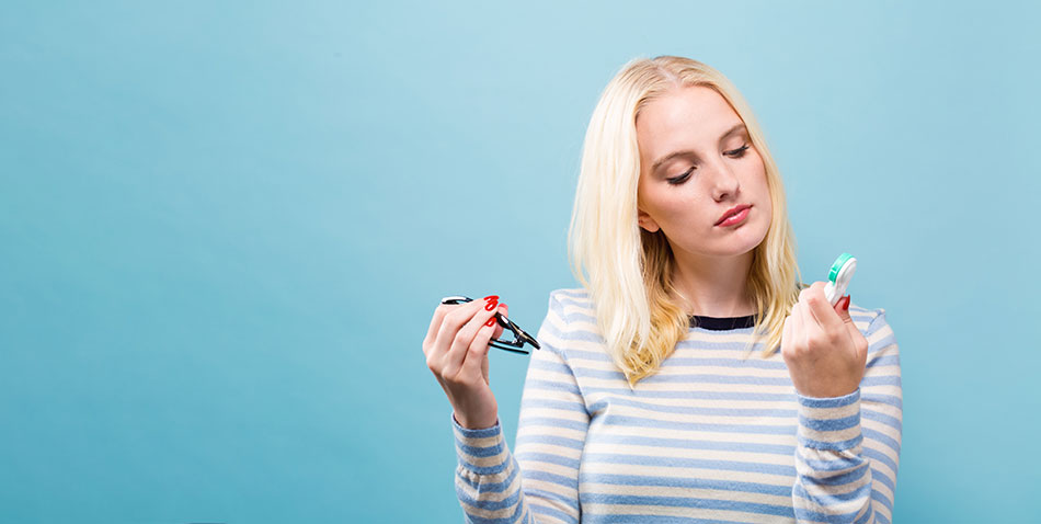 Woman choosing between glasses and contacts