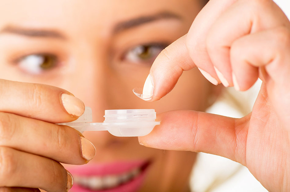 woman removing contact lens from case