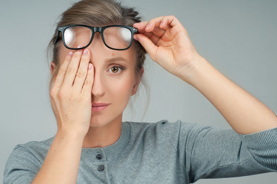 woman wearing glasses covering one eye