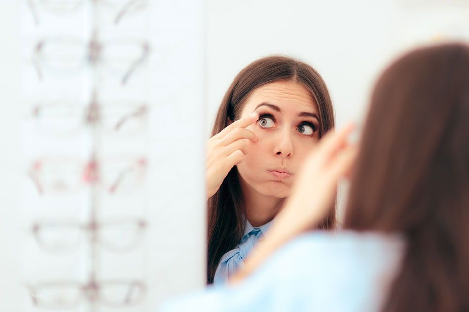 Woman having trouble putting in contacts