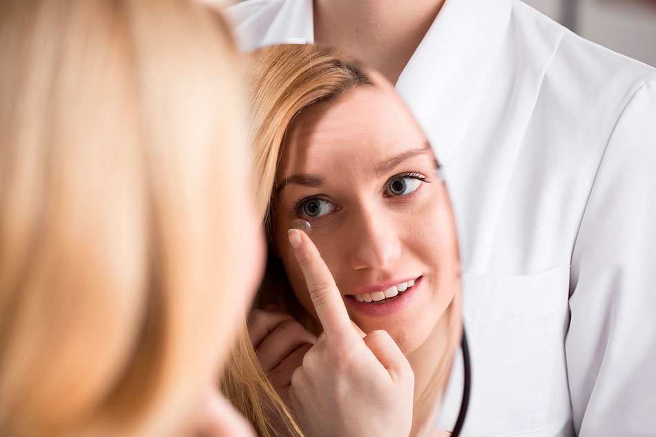 woman leaning to put contact lenses in