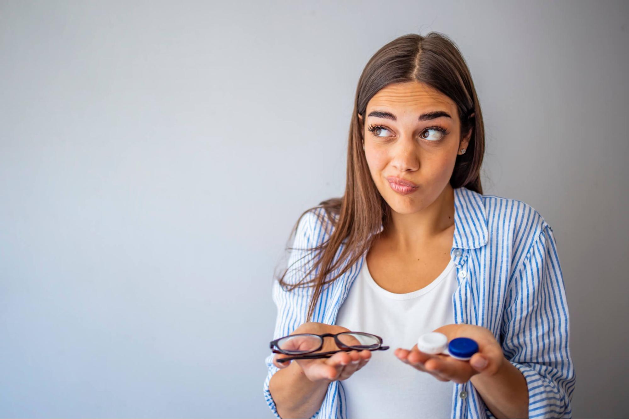 Woman choosing between reading glasses and multifocal contact lenses
