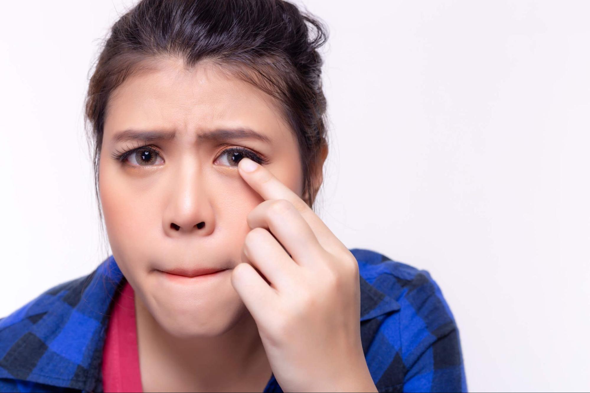 Woman inserting a contact lens into her eye