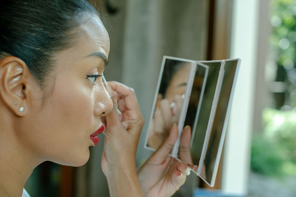 Woman removing contact lens from her eye