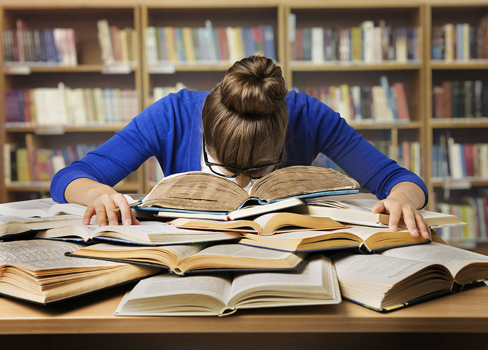 college girl studying hard and sleeping on books in the library