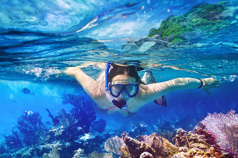 young woman snorkeling in tropical water