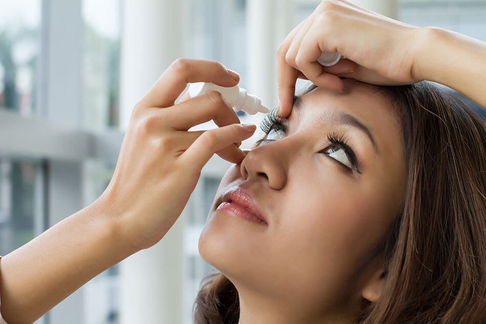 Woman using saline drops in her eyes wondering “why are my contact blurry?”